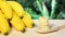 Banana on wooden board, sliced on wooden spoon, bamboo background