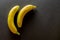 Bananas background. Yellow banan on black background. Exotic food concept Fruit minimal concept. Flat lay.