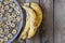 Bananas and banana chips on wooden table in horizontal orientation. Trendy ugly organic fruit