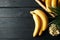 Bananas Basket with bananas and bowl with slices on wooden background