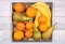 Bananas, conference pears, tangerines and kiwis placed in an old wooden tray on a background of old wooden floor