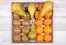 Bananas, conference pears, tangerines and kiwis placed in an old wooden tray on a background of old wooden floor