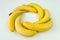 Bananas folded in the shape of a circle lie on a white background of the table. top view, above view