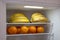 Bananas and oranges in open fridge. Fresh vitamin fruit breakfast