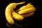 Bananas with some dark spots with shadow isolated on black background.