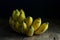 Bananas start to ripen and bruise on a rustic wooden background.