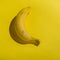 Bananas on yellow background. Pop art. Bright light, strong shadow. Minimalist style