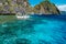 Banca boat moored und crystal clear ocean water near Matinloc island, highlights of hopping trip Tour C. Most beautiful place at