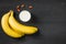 A banch of bananas with almonds and milk on wooden background.