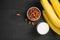 A banch of bananas with almonds and milk on wooden background.