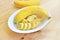 A banch of bananas in a bowl over a wooden t