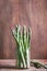 Banches of fresh green asparagus on wooden background