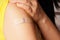 Bandage on young woman`s arm after scratch on skin or injection for vaccine. A medical patch or plaster with the number 3 on it,