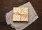 Bandaged stack of baked square matzoh on a gray napkin