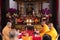 Bandung, Indonesia - January 8, 2022 : The monks sitting on the chair while praying on the altar in orange costumes