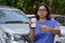 Bangalore, India, 2020. Girl showing Ola app on her mobile phone screen while standing in front of her fleet of cars. Its an