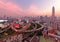 Bangkok at rosy dusk with skyscrapers in background and busy traffic on elevated expressways & circular interchanges