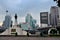 Bangkok skyline with BTS overhead skytrain and King Rama VI statue Lumphini Park Thailand