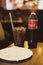 Bangkok, Thailand - February 22, 2020: Half consumed Coca-cola bottle and coca cola in glass with ice