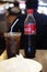 Bangkok, Thailand - February 24, 2020: Half consumed Coca-cola bottle and coca cola in glass with ice