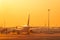 BANGKOK, THAILAND-FEBUARY 20, 2020 : Airplane parked at airfield of airport with golden sunrise sky. Summer travel concept.