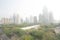 BANGKOK, THAILAND JAN 21, 2019 ; Bangkok skycrapper office building gray out covered by PM 2.5 dust with green tree in public park