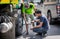 BANGKOK, THAILAND - JUNE 15: Unnamed truck drivers tighten wheel lugs after changing wheel at the road side in June 15, 2019