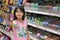 BANGKOK, THAILAND - MAY 02: Unnamed asian girl selects favorite candy from the sweet section in Foodland supermarket in Bangkok on