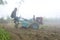 Bangladesh â€“ January 06, 2014: On a foggy winter morning, a farmer is plowing his land with a 2-wheel tractor at Ranisankail,