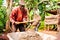 Bangoua, Cameroon - 08 august 2018: old african man doing manual work with shovel and concrete building water well in sunndy day