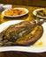 Bangus fillet with garlic bits, among other various dishes at a restaurant