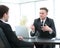 Bank employee sitting behind a Desk and talks to the client