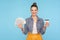 Bank loan, cash deposits. Portrait of happy cute fashionably dressed woman with hair bun holding credit card and dollar banknotes