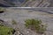 Bank ruined mountain river and fallen tree.