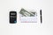 Banknotes in airmail envelope and black pen with calculator on white background.
