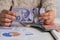 Banknotes of Canadian currency: Dollar. Person handling papernotes on desk.