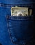 Banknotes close up, money in a jeans pocket. Dollars stick out of the jeans pocket, finance and currency concept. Concept of