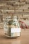 Banknotes of dollars in a glass jar and a place for signature - copyspace - piggy bank and stash