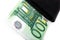 Banknotes of hundred euros sticking out of black wallet closed,