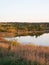 The banks, sky, and trees are reflected in the surface of the water. Lake in the autumn season. Beautiful romantic autumn dreary