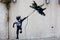 Banksy street art graffiti boy with fighter aircraft kite in Tel Aviv, Israel