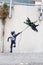 Banksy street art graffiti boy with fighter aircraft kite in Tel Aviv, Israel