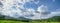 Banner Beautiful landscape mountain green field grass meadow white cloud blue sky on sunny day. panoramic Majestic green scenery