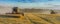 Banner combine harvester on a wheat field with blue sky