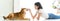 Banner cover design. Jocund young Asian woman lying on floor playing with Shiba Inu, Japanese dog. Cheerful and nice couple with