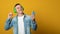 Banner. Handsome young man with earphones holding mobile phone isolated on yellow background. Copy space