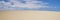 Banner header of nature landscape with yellow and blue colors. Desert dune and blue sky with clouds. Climate change warming