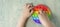 banner with Kid playing with pop it sensory toy. boy pressing on colorful rainbow squishy soft silicone bubbles. Stress