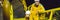 BANNER, LONG FORMAT Young man and a little boy are both in a yellow work uniform, glasses, and helmet in an industrial