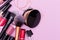 Banner. Make up the essentials. A set of professional makeup brushes and cosmetics on a pink background.